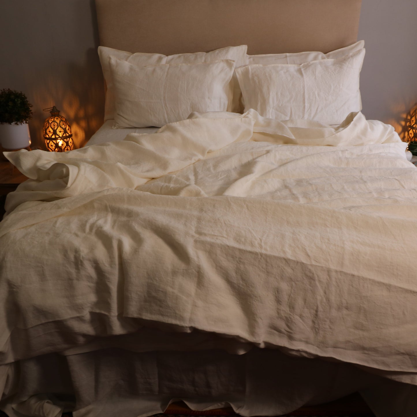 Unmade bed with white sheets in a dimly lit bedroom
